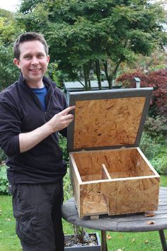 a man standing next to an open wooden box