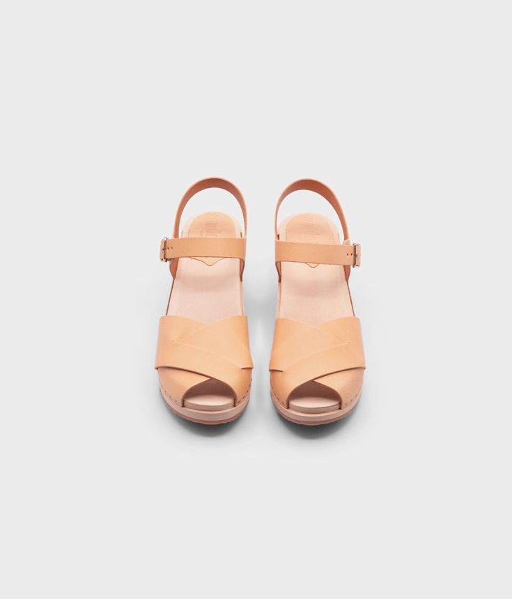 Embrace retro-inspired glamour with our high-heeled clog sandals, complete with an open-toe design that adds a modern twist to a classic silhouette. Perfect for pairing with your favorite dresses or jeans for a chic and stylish look. Clog measurements:Heel height: 2 5/8” (6.5 cm)Toe height: 1 1/2” (3.8 cm) Fit:NarrowLeather:Nubuck leatherClogs consist of:Base: European Lime Wood Sole: Rubber sole Fastening: Staples Other: Metallic buckle High Heel Clogs, Cork Sandals, Clog Sandals, Wooden Clogs, Boot Shop, Toe Designs, Favorite Dress, Retro Inspired, Open Toe