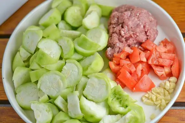 a white bowl filled with chopped vegetables on top of a wooden table