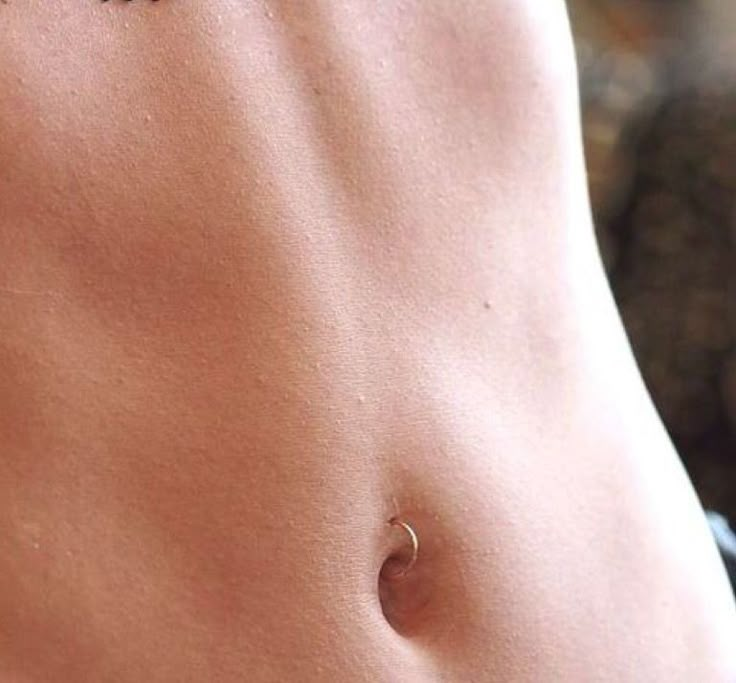 a close up of a person's stomach with small tattoos on their back and side