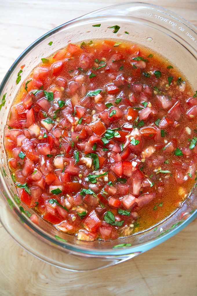 a glass bowl filled with lots of food on top of a wooden table