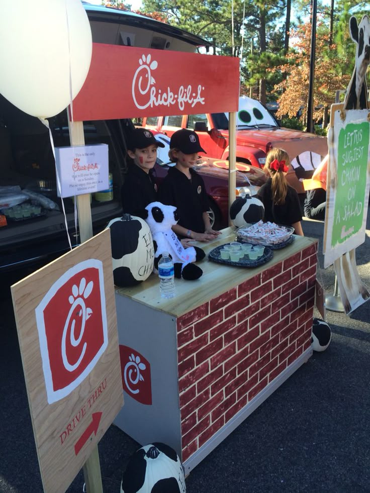 some people are standing at a booth selling food