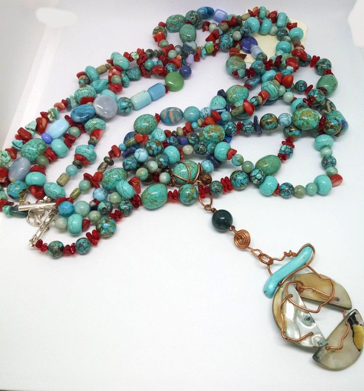 This is a 4 strand glass,stone, and metal beaded statement necklace. It is comprised of glass and stone (carnelian,agate,coral, dyed howlite, turquoise, jasper, lapis, shattuckite, abalone) beads in shades of red and blue, copper wire, silvertone jump rings, and a silvertone lobster claw clasp. The necklace is strung on nylon coated steel wire.Shortest strand = 19" Longest strand = 30" Focal = 4.25" Bohemian Multi-strand Turquoise Necklace With Natural Stones, Bohemian Multi-strand Agate Necklace, Unique Multi-strand Gemstone Beads, Unique Multicolor Jasper Necklaces, Bohemian Jasper Necklace With Polished Beads, Unique Turquoise Agate Necklace With Gemstone Beads, Unique Multi-strand Turquoise Necklace Gift, Unique Multicolor Jasper Jewelry, Bohemian Multi-strand Agate Jewelry