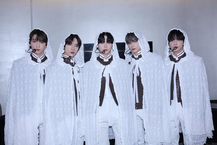 five men in white costumes with brown ties