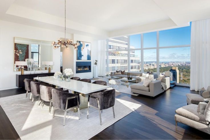 a living room filled with furniture and large windows