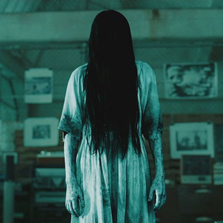 a woman with long hair standing in a room