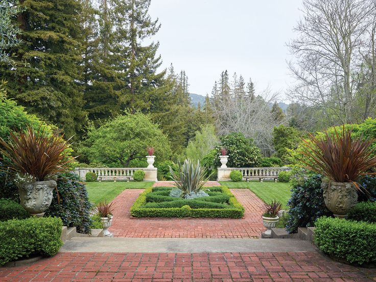 a brick walkway leads to a formal garden