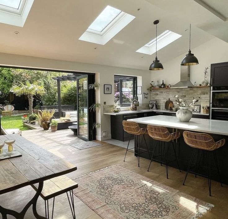 an open kitchen and dining room with skylights