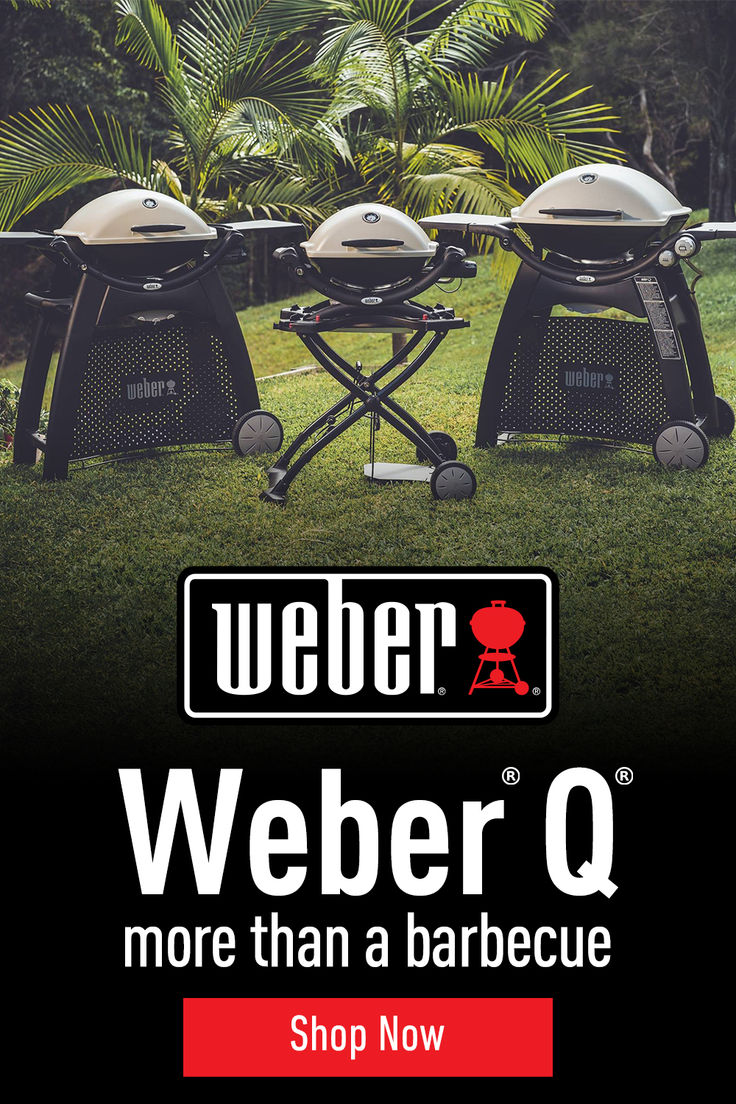 two barbecue grills sitting on top of a grass covered field