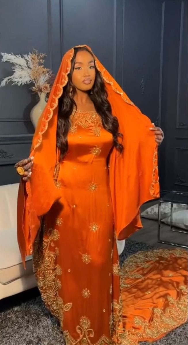 a woman in an orange dress and shawl