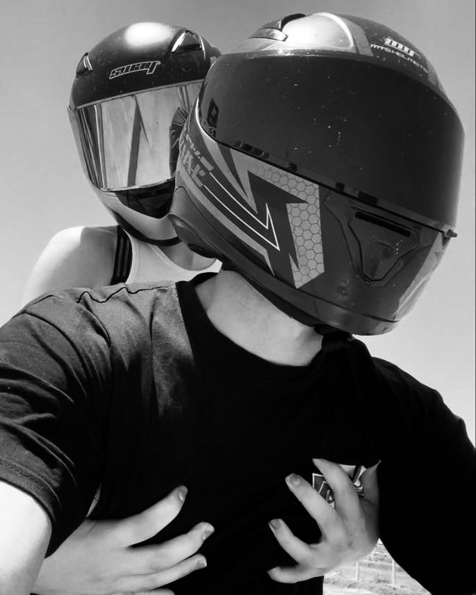 two people wearing helmets are hugging each other