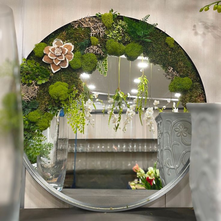 a mirror with plants and flowers in it