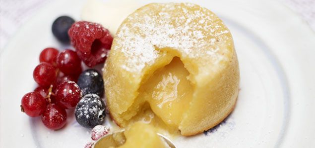 a white plate topped with fruit and pastry next to powdered sugar on top of it