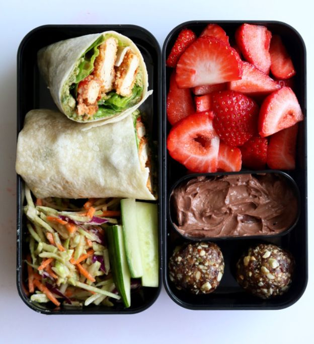 two black trays filled with fruit and veggies next to chocolate covered strawberries