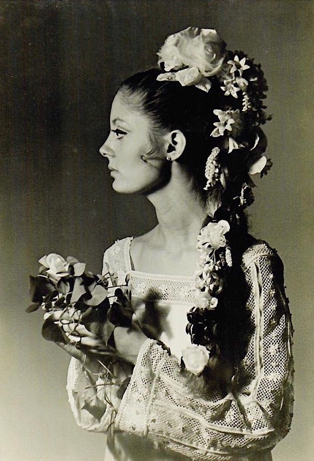 an old photo of a woman with flowers in her hair