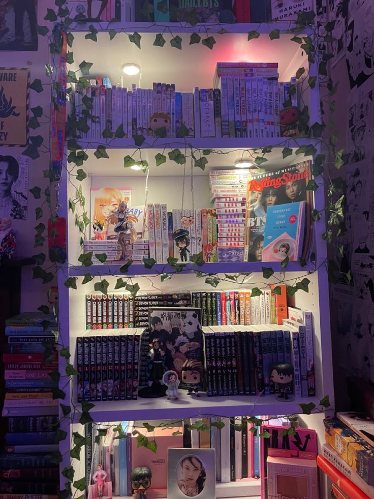 a book shelf filled with lots of books next to a wall covered in posters and plants