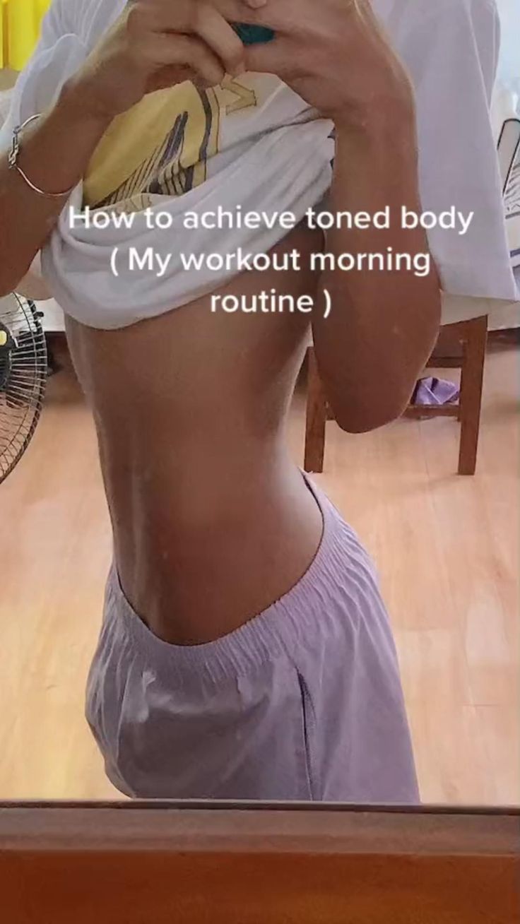 a woman taking a selfie in front of a mirror with her cell phone and texting how to achieve toned body my workout morning routine