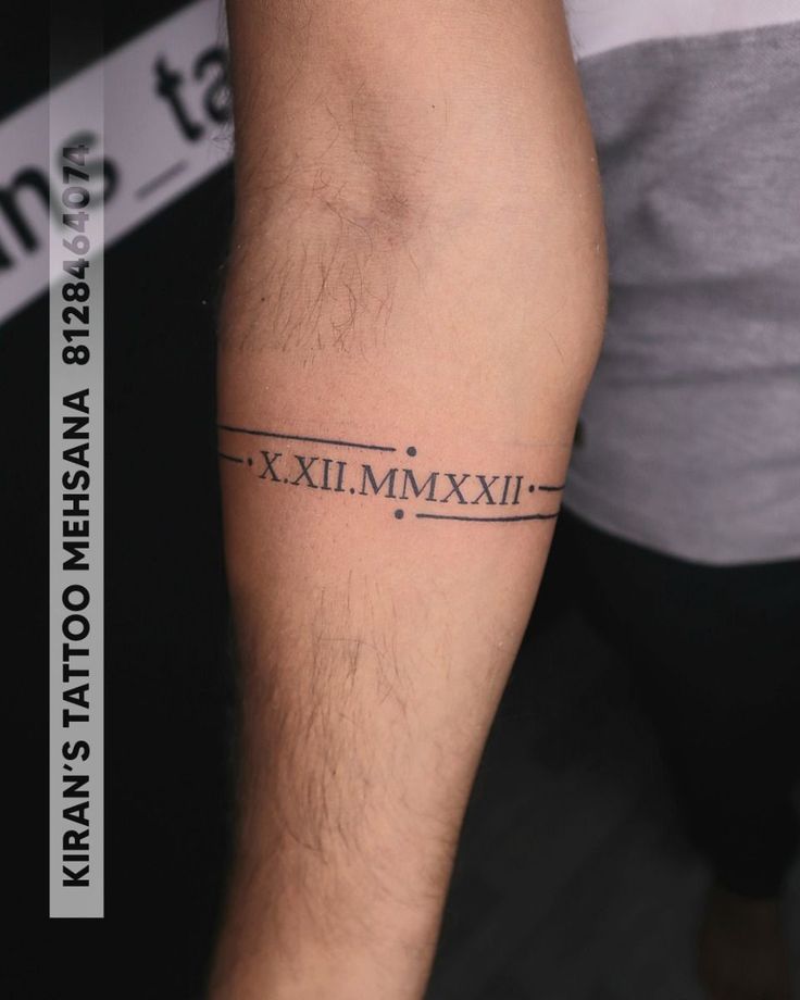 a man's arm with roman numerals tattoo on the left side of his leg