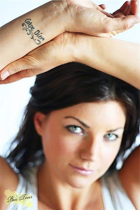 a woman is holding her arm up with the word love tattooed on it's wrist