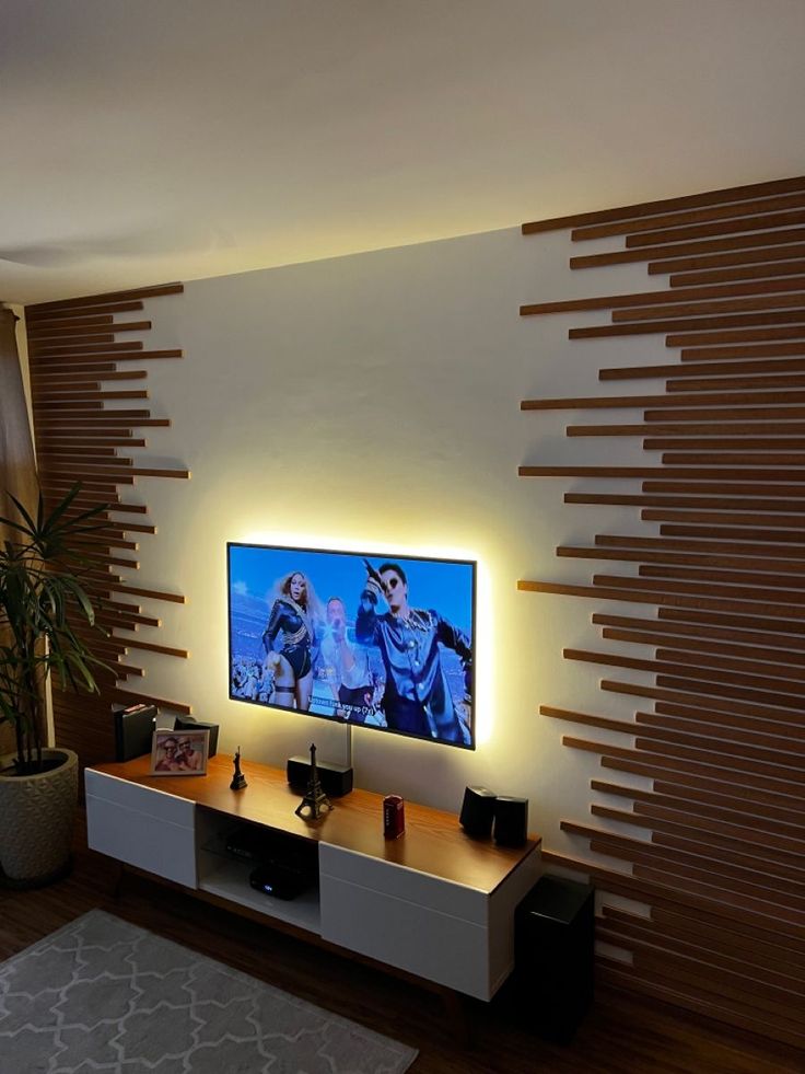 a flat screen tv sitting on top of a wooden entertainment center in a living room