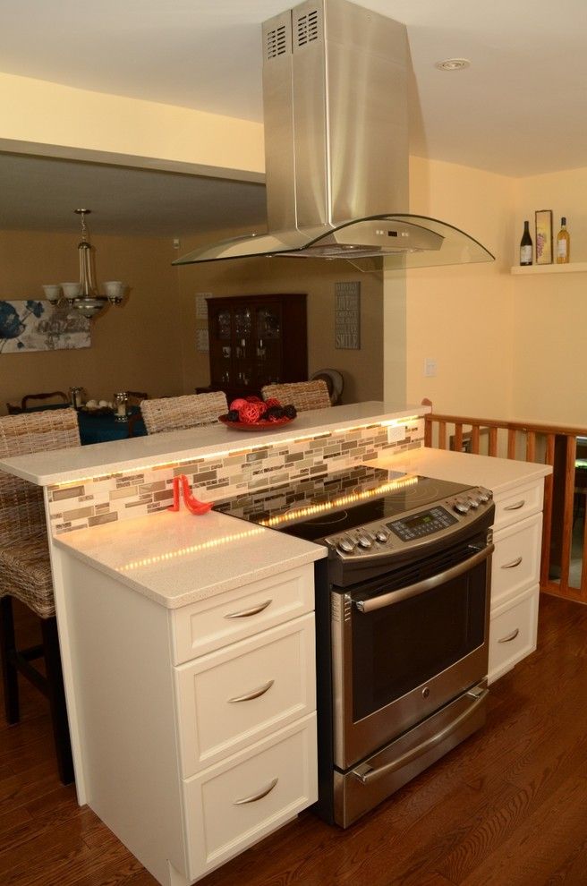 a kitchen with an oven, stove and dining room table in the backround