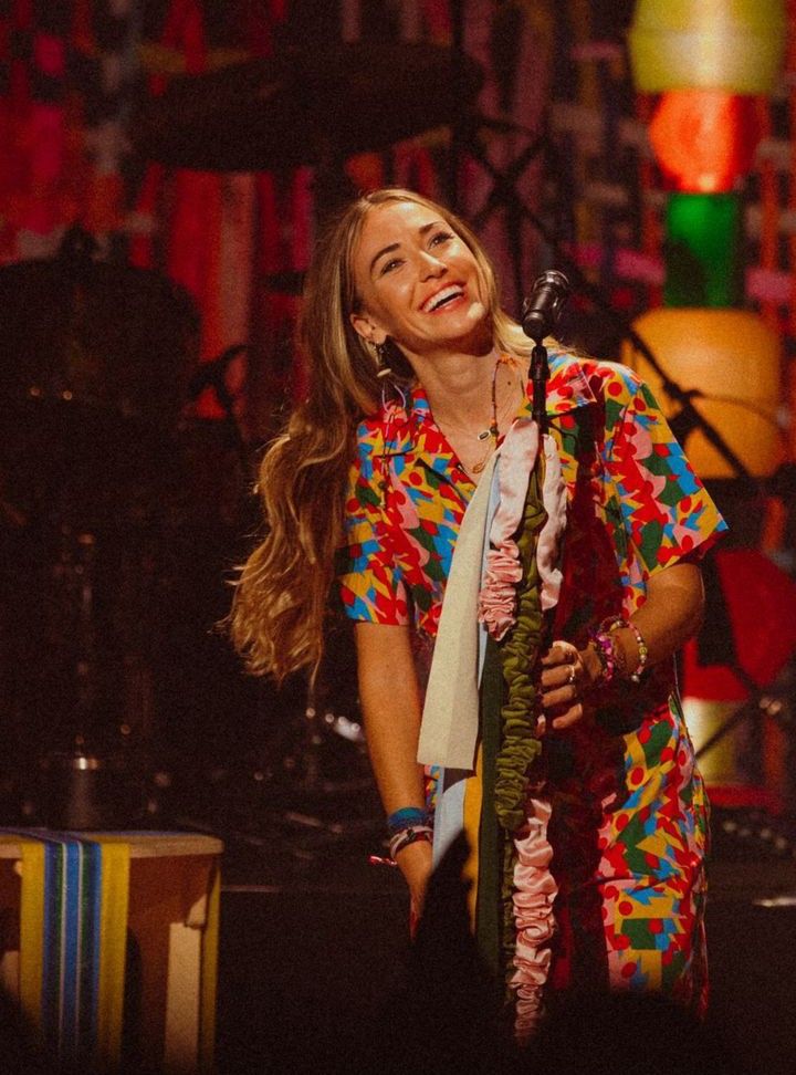 a woman standing in front of a microphone on stage