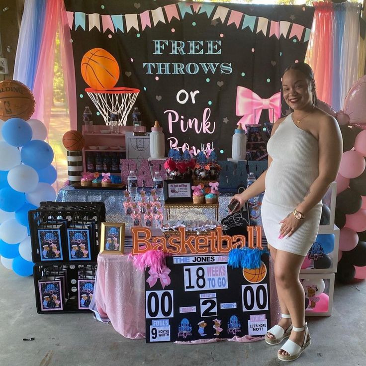 a woman standing in front of a table with balloons and other items on it at a basketball themed birthday party