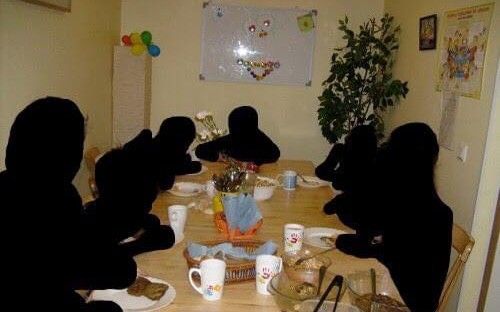 the silhouettes of people sitting at a table with plates and cups in front of them