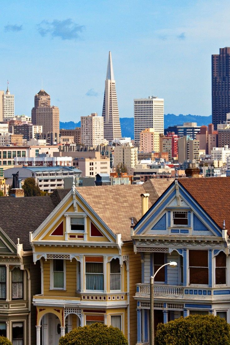 the houses are painted in different colors and sizes, along with the cityscape behind them