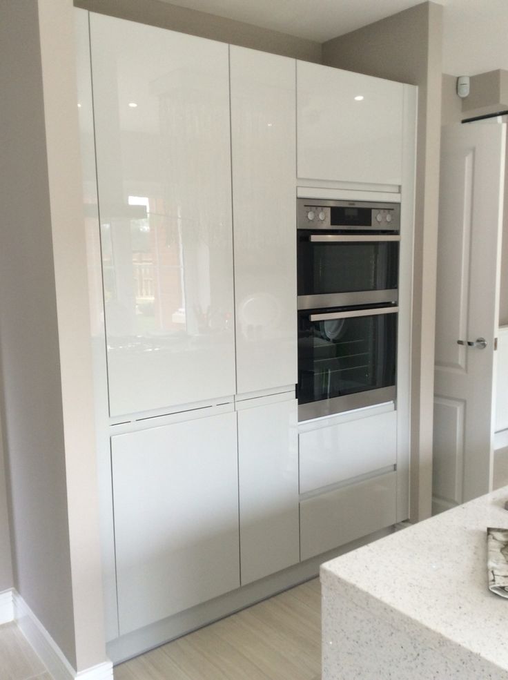 a kitchen with two ovens in the middle of it and white cabinets on both sides