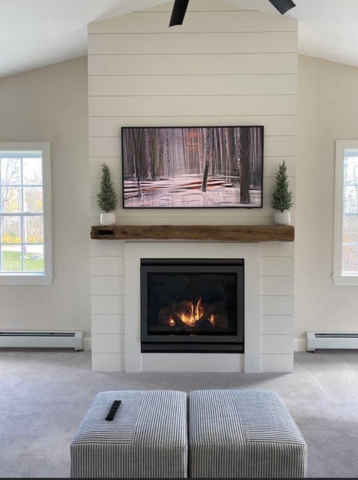 a living room with a fire place and couch in front of the tv on the wall