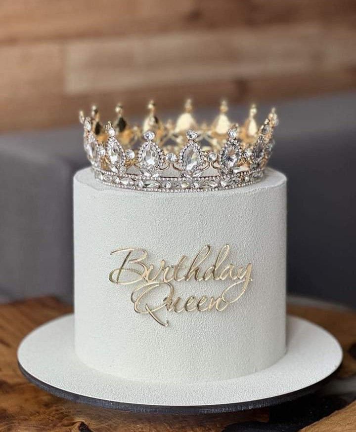 a white and gold birthday cake with a crown on top