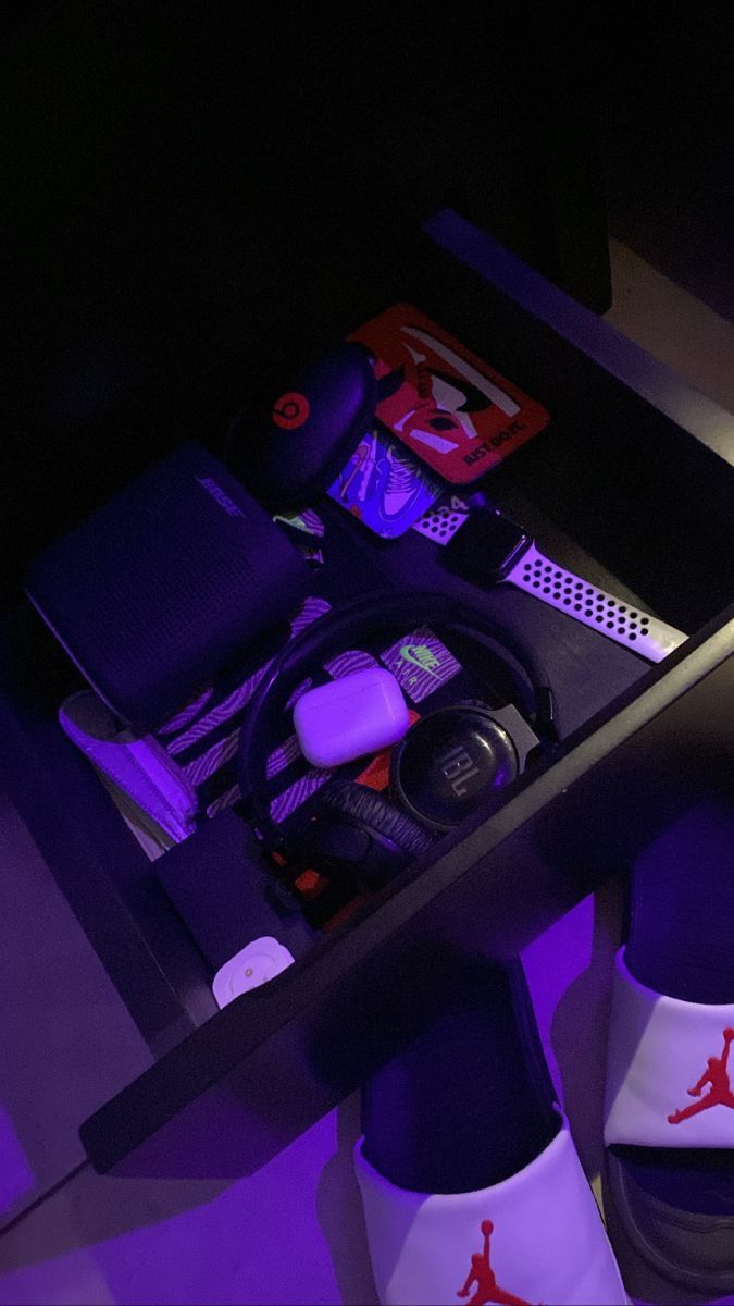 a pair of white shoes sitting on top of a table next to a purple light