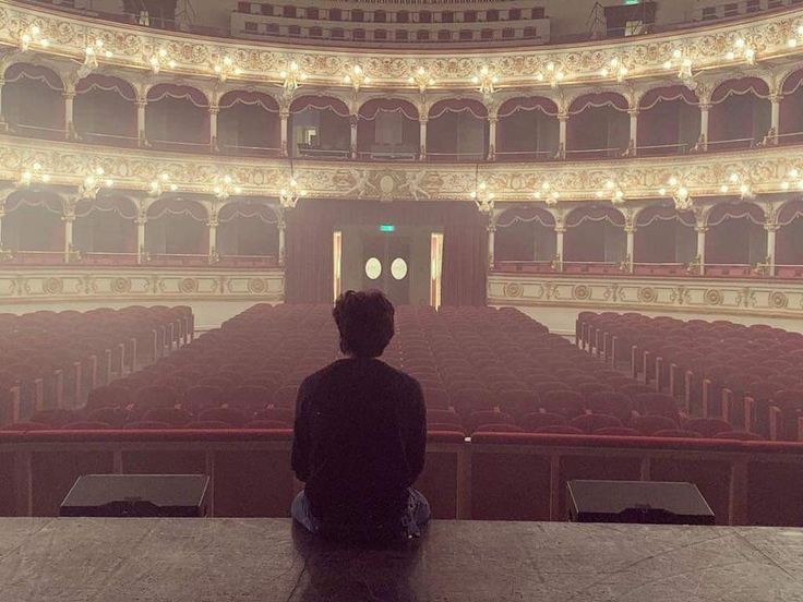 a person sitting in front of an empty auditorium