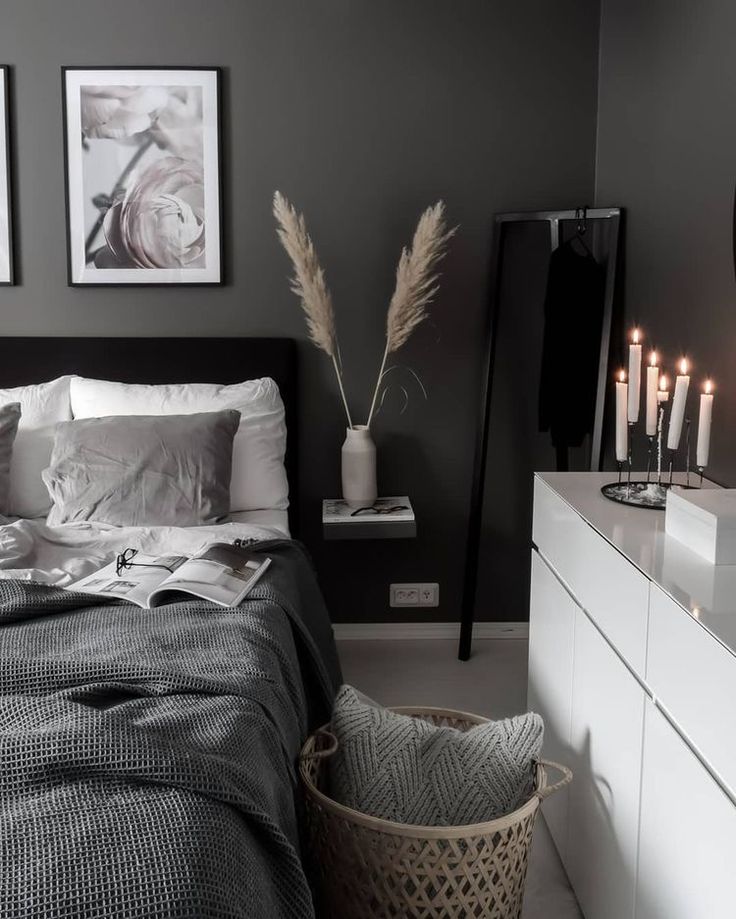 a bedroom with grey walls, white furniture and pictures on the wall above the bed