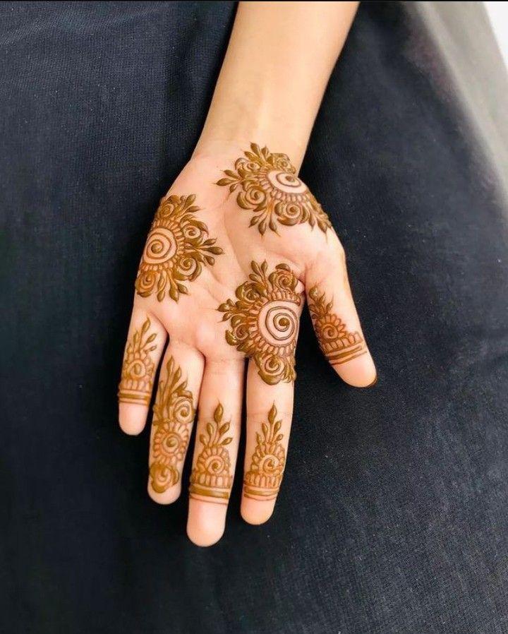 a woman's hand with henna tattoos on it