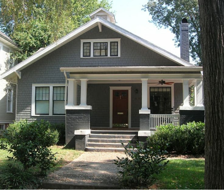 a gray house with white trim on the front door and steps leading up to it