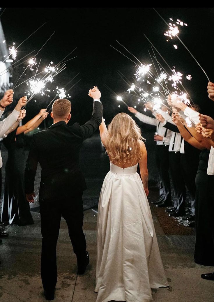 the bride and groom are holding sparklers in their hands