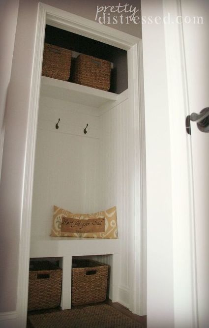 a white closet with baskets and pillows on it