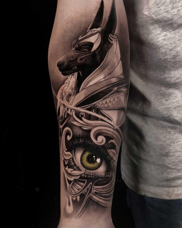 a man's arm with tattoos on it and an eye in the middle,