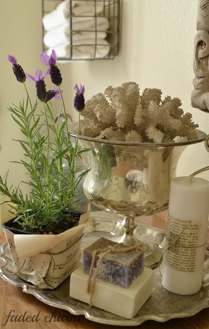 a tray with soaps, candles and flowers on it