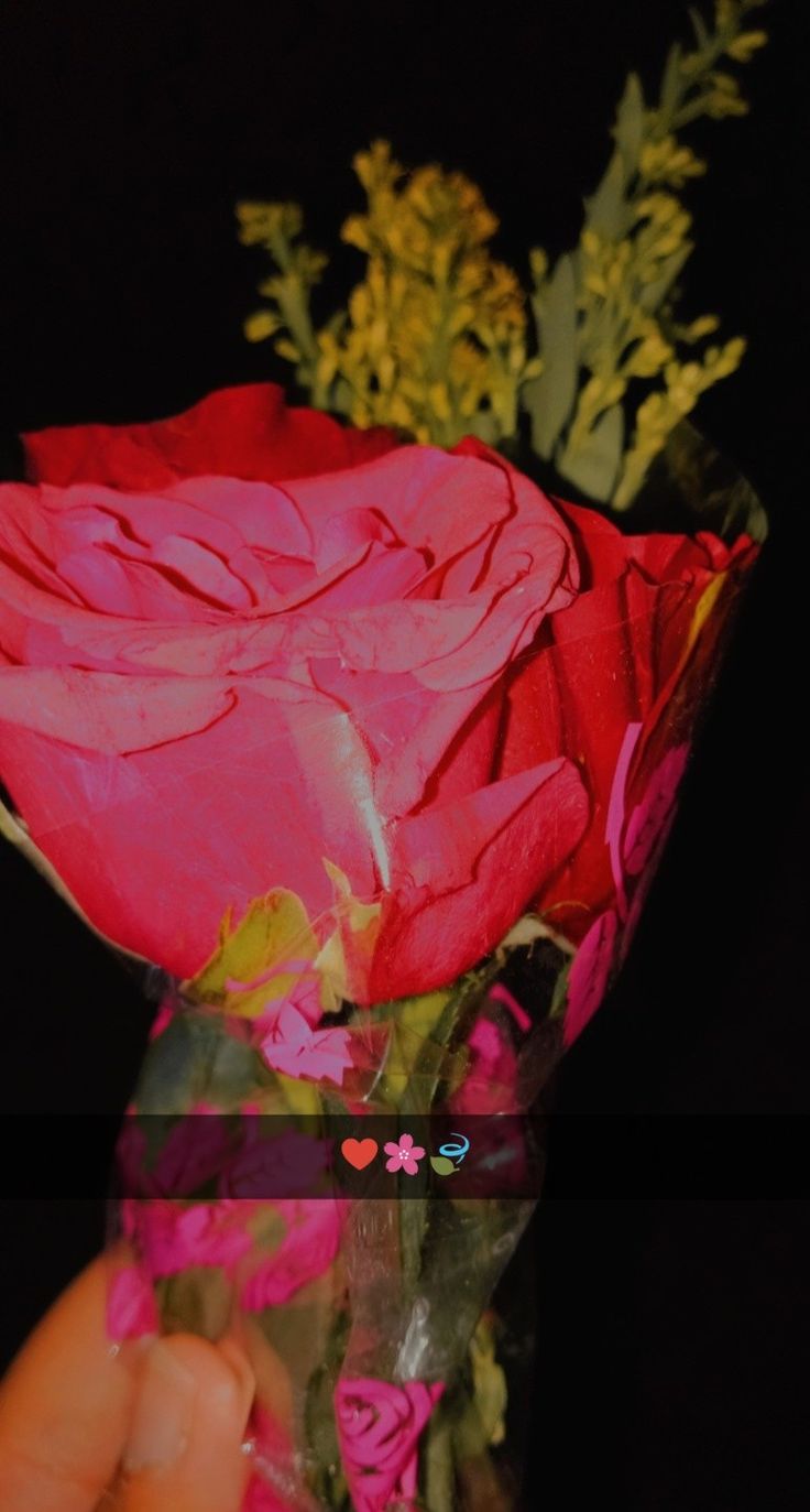 a person holding a bouquet of flowers in front of a black background with the words love written on it