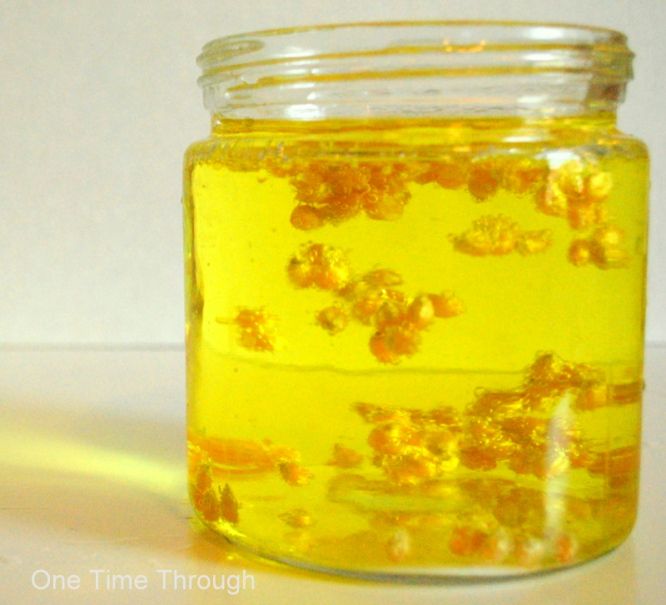 a jar filled with yellow liquid sitting on top of a table