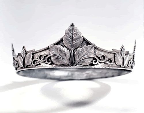 a silver crown ring with leaves on the front and sides, set against a white background