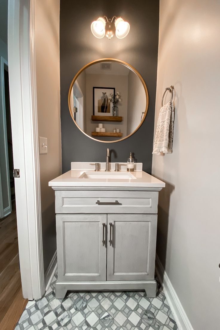 a bathroom with a sink, mirror and lights on the wall next to an open door