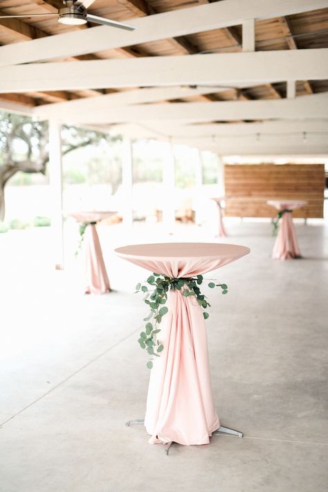 the tables are covered with pink cloths and greenery