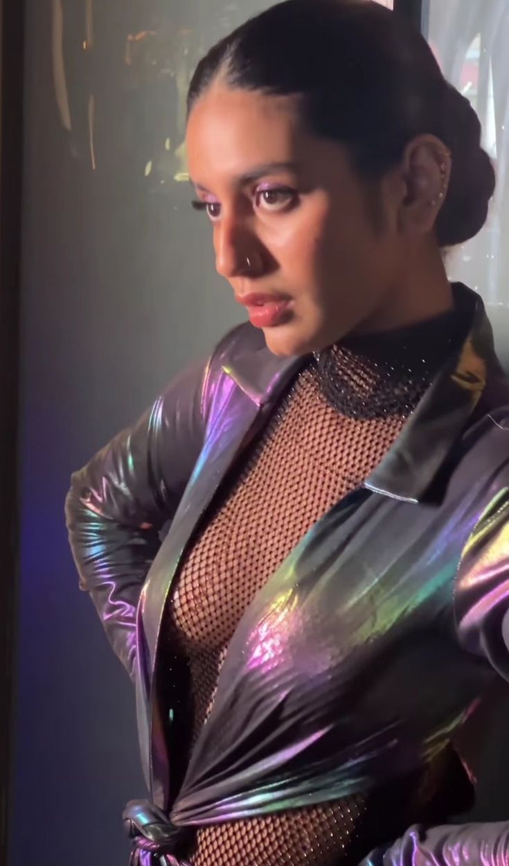 a woman in a shiny jacket posing for the camera