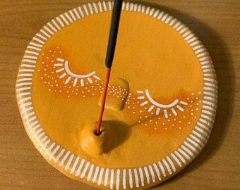 a clock made to look like the face of a sun with eyes painted on it