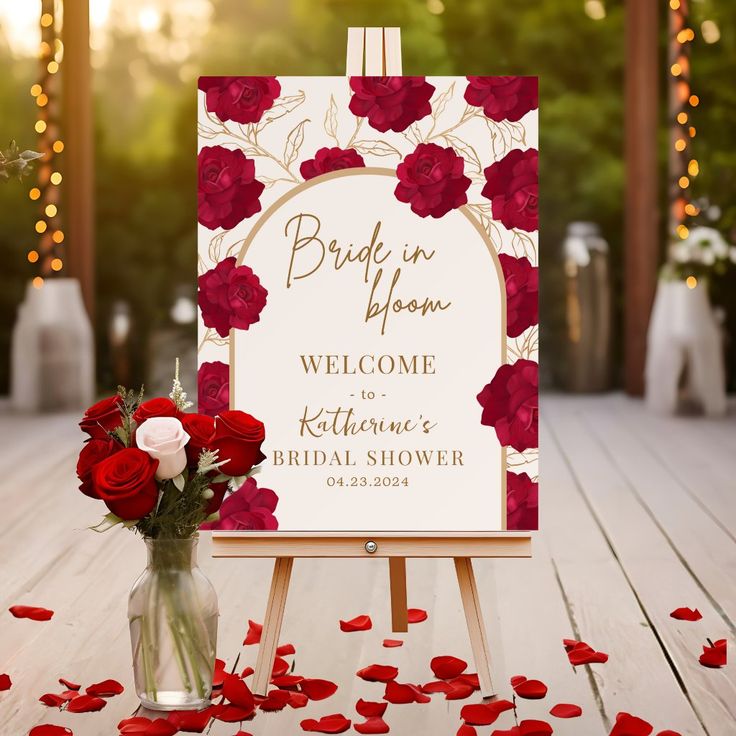 a bouquet of roses in a vase next to a welcome sign on an easel