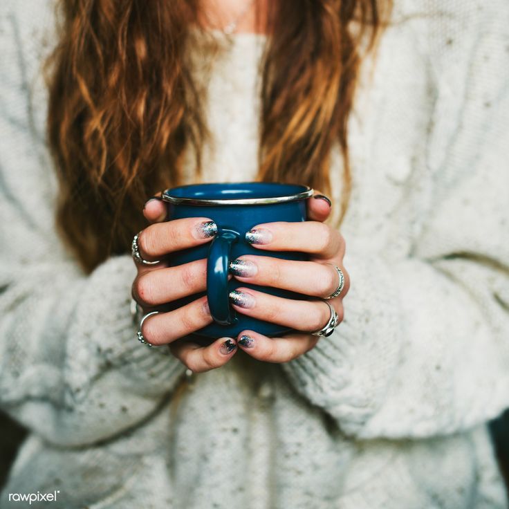 a woman holding a cup in her hands with nail polishes on it's fingers